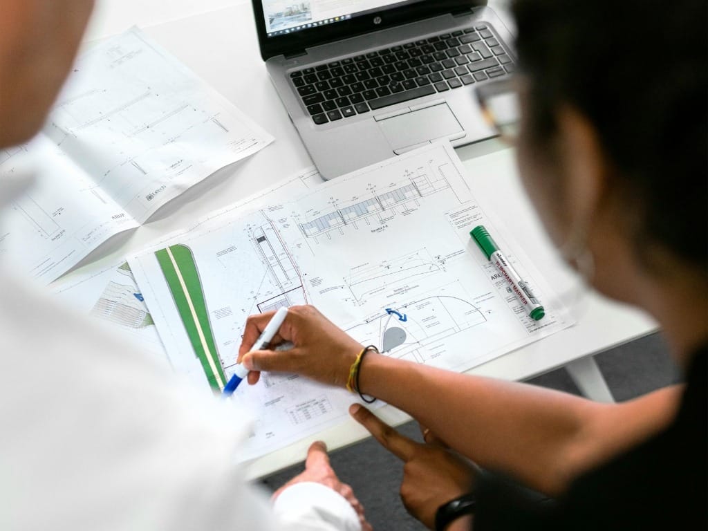Architects discussing project management plans and architectural designs in Milton Keynes.