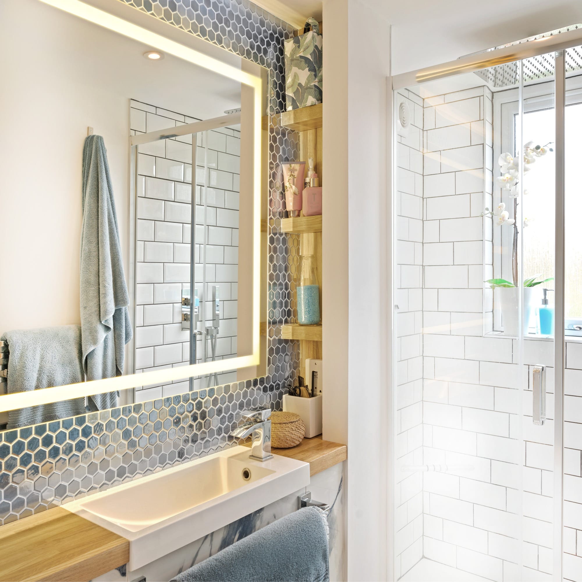 Modern bathroom design with hexagonal tiles, illuminated mirror, and glass shower in Milton Keynes, Two Mile Ash.